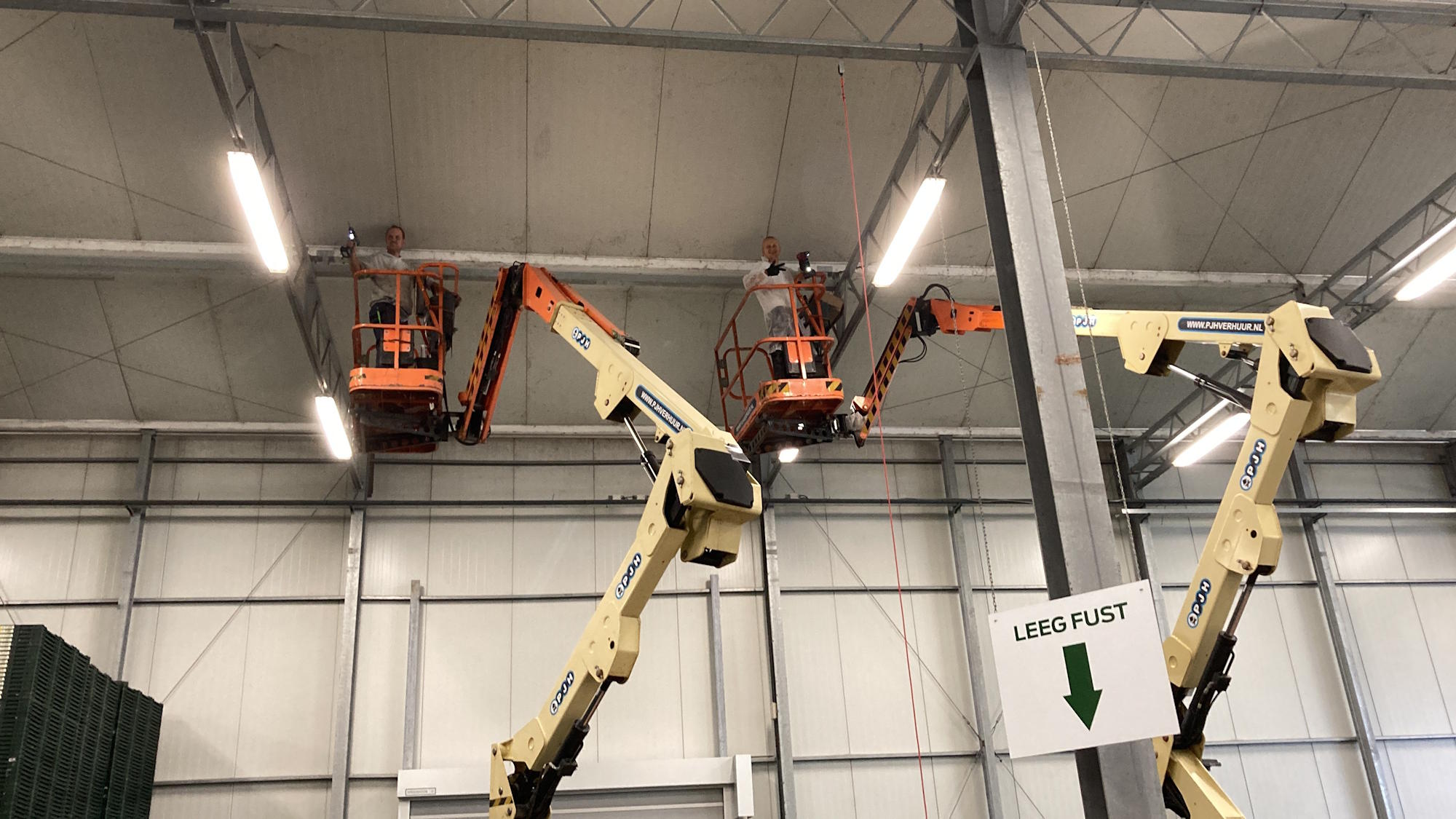 Twee mannen in kranen controleren de constructie